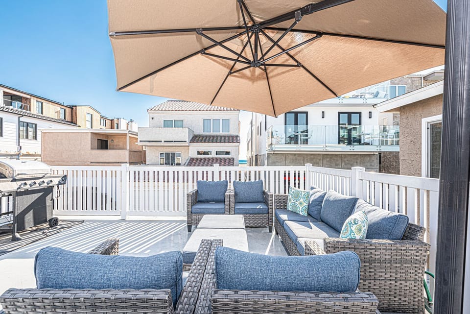 Private deck lounge beneath a market umbrella, perfect for sunset gatherings
                