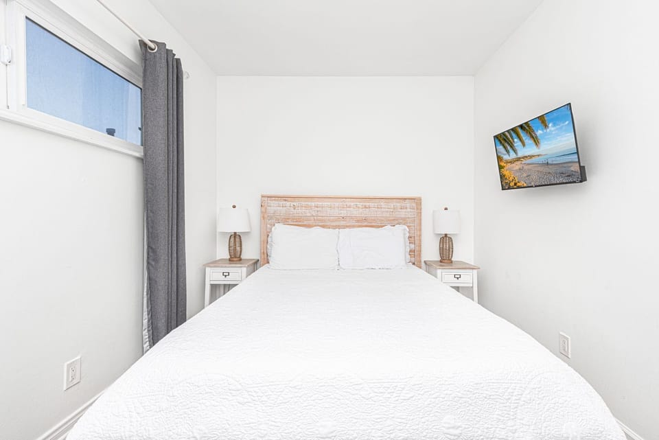 Enjoy this peaceful guest bedroom with a queen-size bed and flat screen TV
                