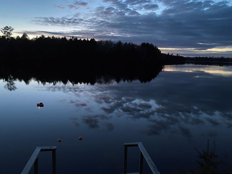 Calm waters show sky reflections.