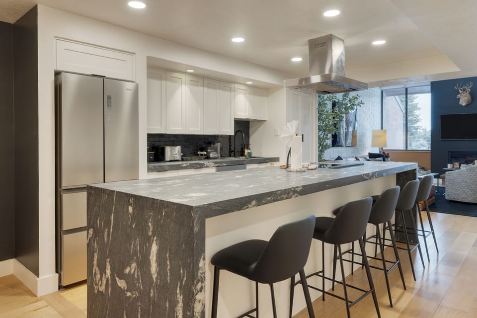 Kitchen features an island with barstool seating.