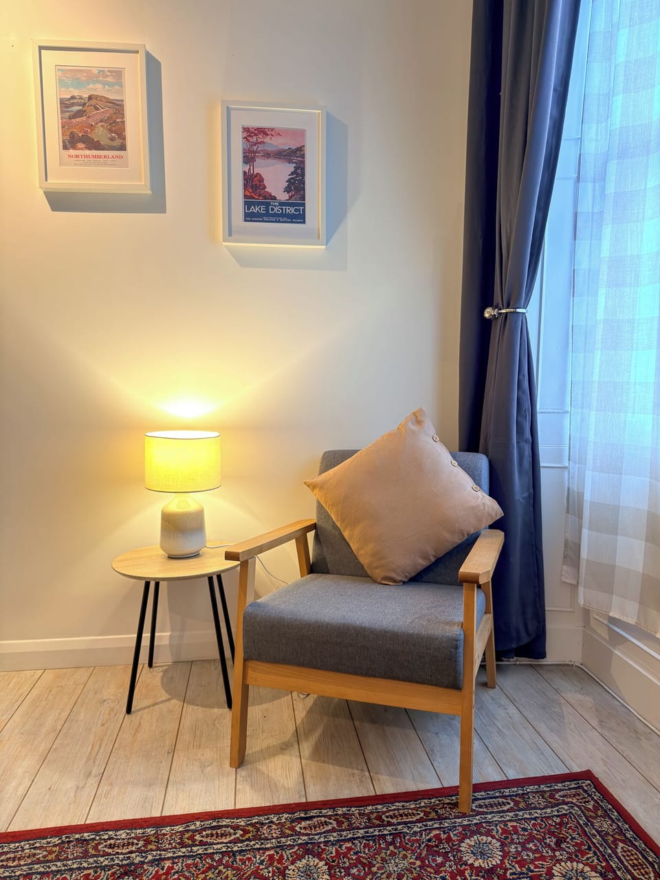Cozy window-side reading nook with warm lighting and modern chair