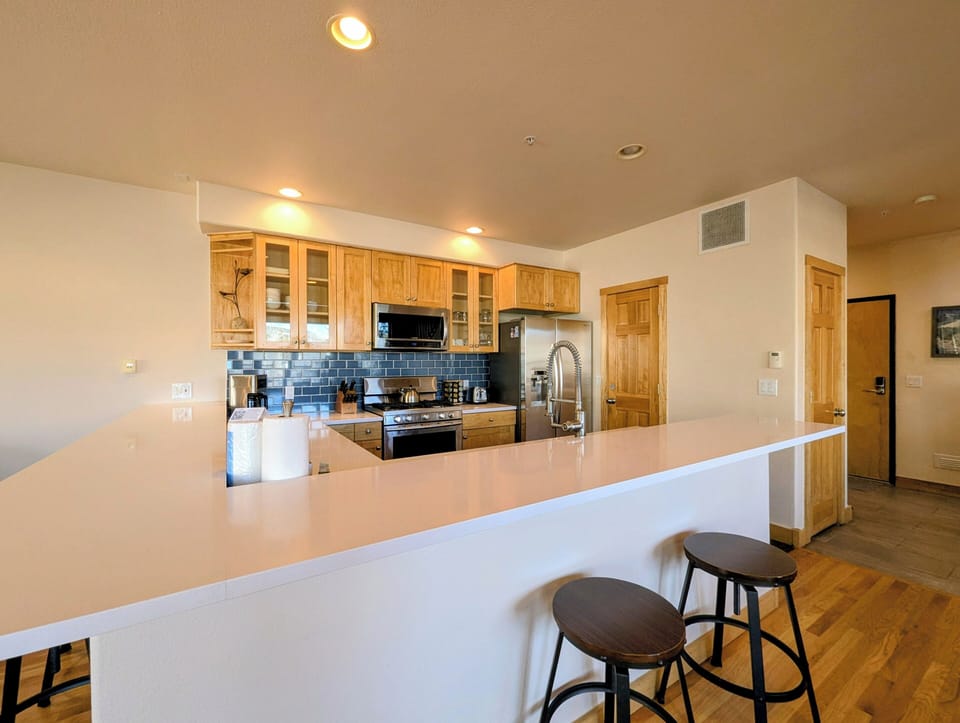 Cook your favorite meals in this bright, fully equipped kitchen featuring warm wood cabinets and spacious counters perfect for gathering.