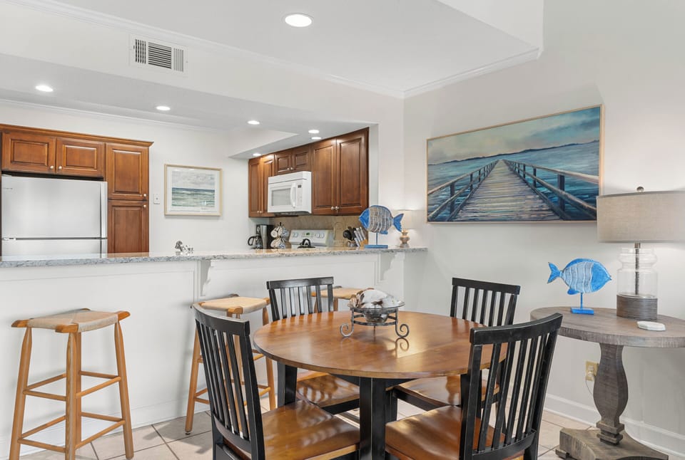Your fully equipped kitchen and dining space invites memorable meals with ocean-inspired art setting the perfect coastal mood.