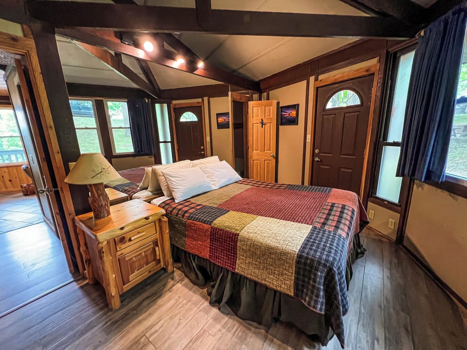 Sink into this cozy bed in your rustic cabin retreat, where warm wood beams, charming décor, and serene natural light invite you to unwind completely.