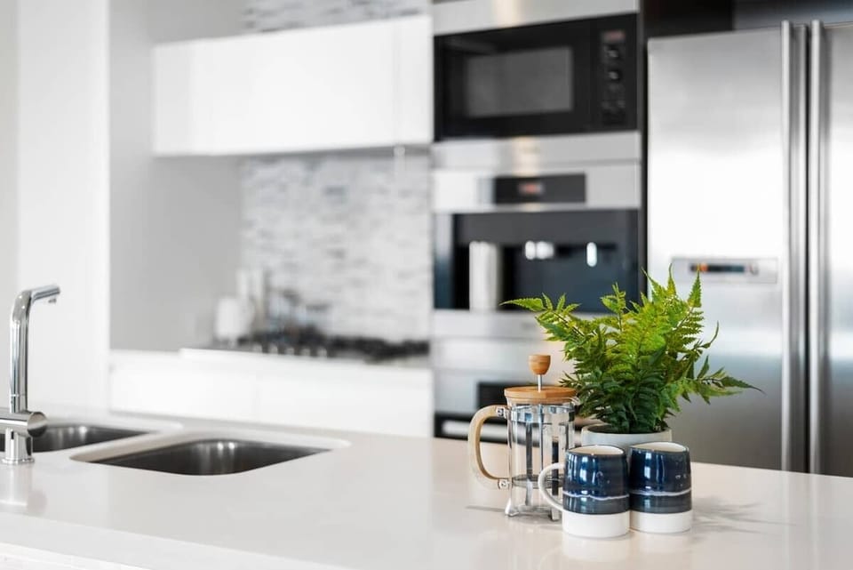 Modern, bright kitchen with European appliances and stone countertops.
