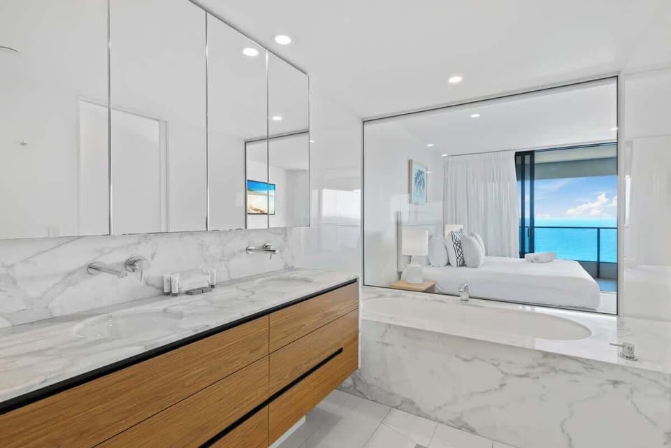 The master bedroom has a modern ensuite with double sinks, a shower and a deep bath.