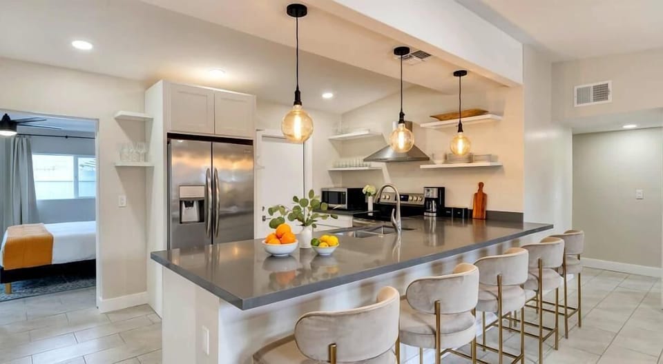 The fully equipped modern kitchen is stocked with all culinary essentials, stainless-steel appliances and breakfast bar seating.
