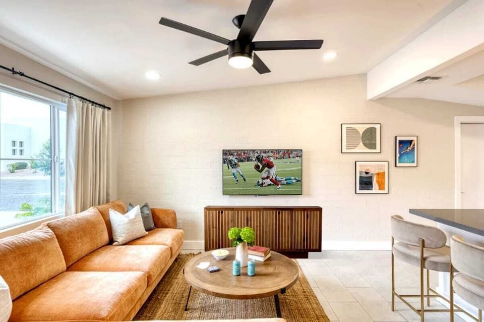 Bright open floor living space featuring a smart flat-screen TV, and designer furnishings.