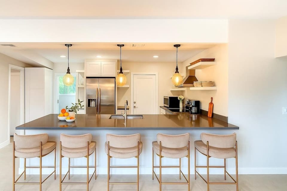 The fully equipped modern kitchen is stocked with all culinary essentials, stainless-steel appliances and breakfast bar seating.