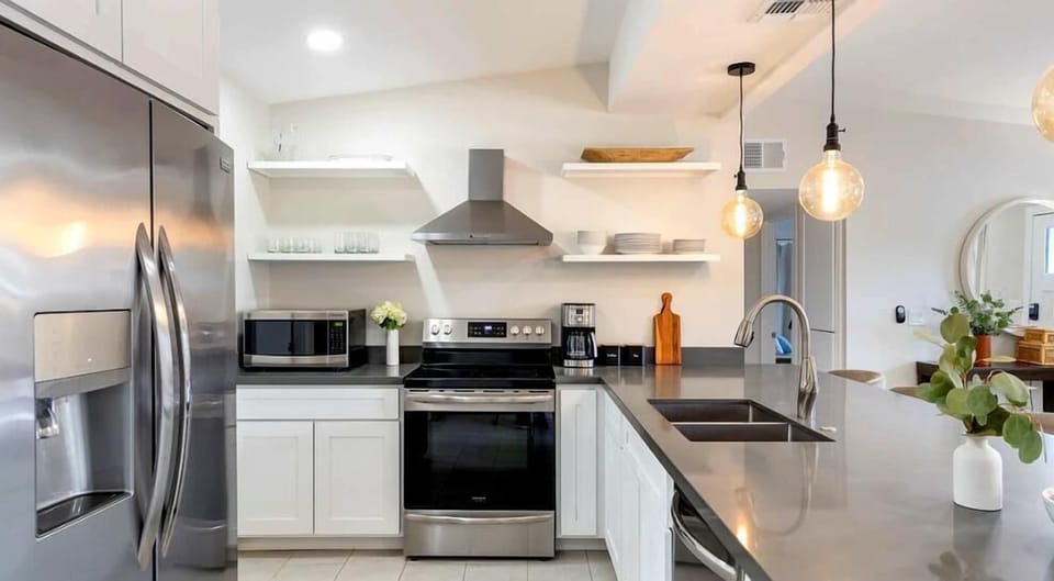 The fully equipped modern kitchen is stocked with all culinary essentials, stainless-steel appliances and breakfast bar seating.