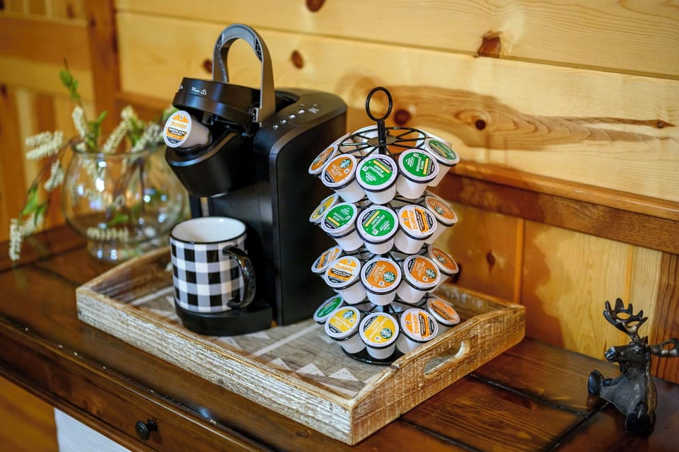 Start your mornings right with a full coffee station at your fingertips—featuring a single-serve brewer, a curated selection of pods, and charming rustic touches that make every cup feel special.