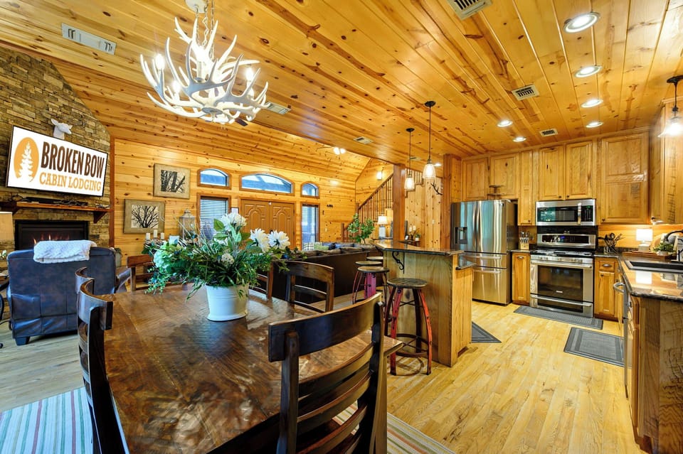 Gather around this handcrafted wood table beneath stunning vaulted ceilings while your full kitchen awaits every meal you'll create together in this warm, mountain-inspired retreat.