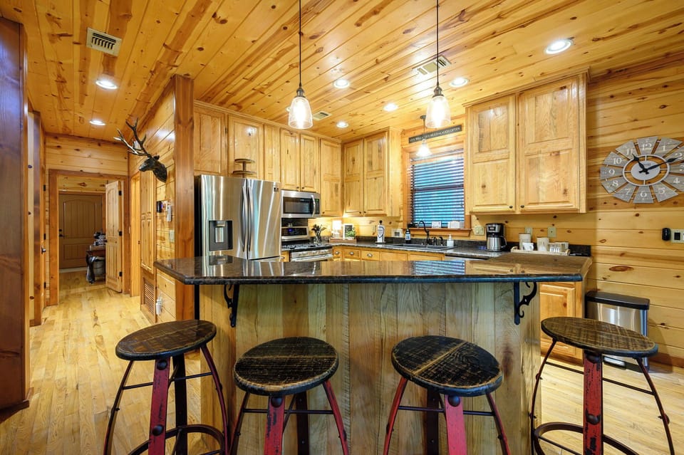 Gather around your spacious kitchen island with its granite countertop and rustic charm, where stainless steel appliances meet warm wood cabinetry under cathedral ceilings that invite you to create and connect.