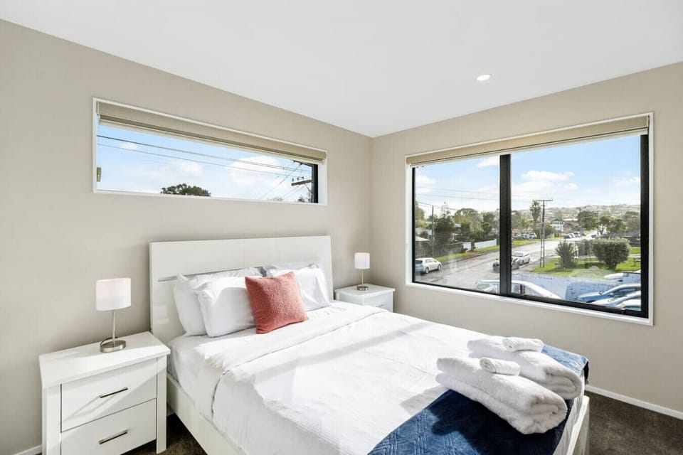 The fourth bedroom has white furniture and a blue throw with apricot cushion.
