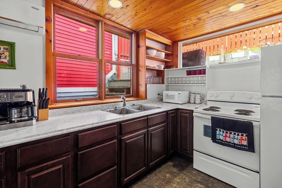 Cook up culinary delights in this spacious kitchen, equipped with a washer and dryer for added convenience. #StJohns