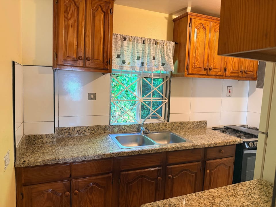 Brand new granite countertops in a full kitchen, full sized stove and refrigerator