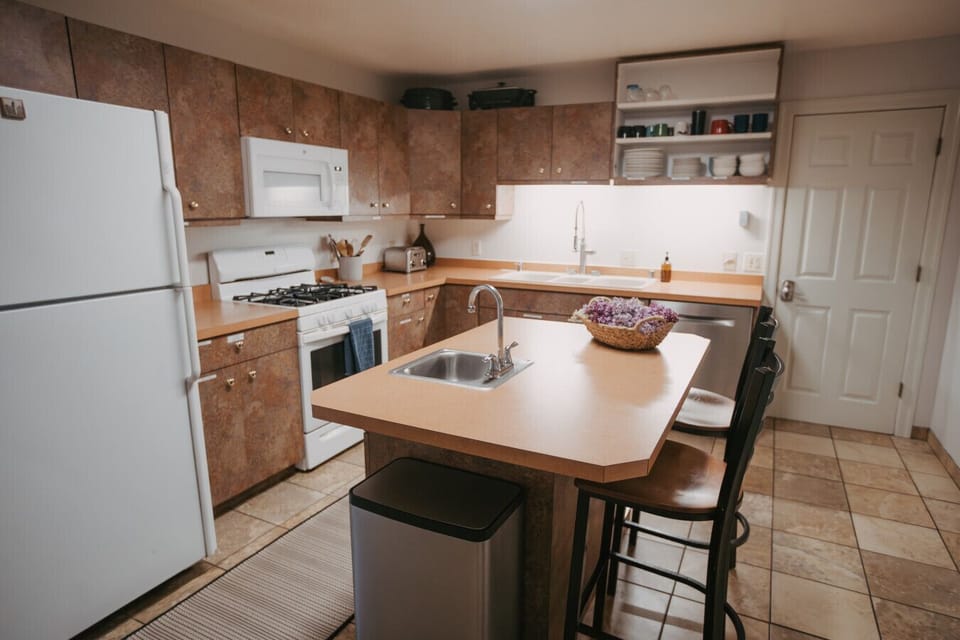 Rattlesnake Apartment #2- A real kitchen for a real stay — gas range, full fridge, dishwasher, and an island with seating for when cooking becomes the social event.