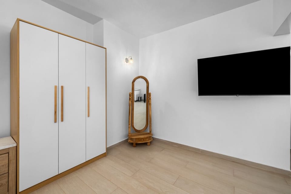 Enjoy the sleek design with a spacious wardrobe, elegant mirror, and a flat-screen TV for your entertainment. Perfect for relaxation and rejuvenation!