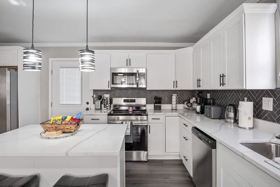 Whip up culinary delights in a fully equipped kitchen- a snack basket too! Enjoy a spacious island and seating for two, a coffee corner, and all the essentials! Direct access to the deck and downstairs area makes this kitchen the heart of the home.