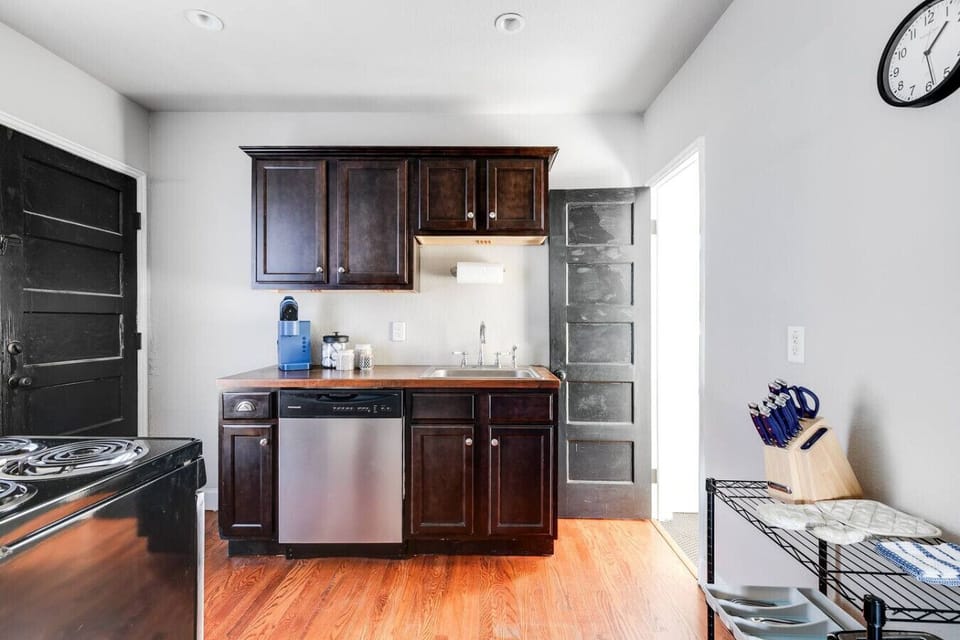 A fully equipped, well-lit space with an oven range, Keurig, dishwasher, and thoughtful touches like a paper towel dispenser. Perfect for whipping up meals or enjoying your morning coffee.