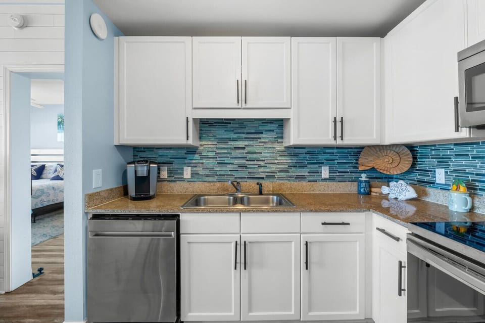 modern kitchen with stainless steel appliances, stylish blue backsplash, and all the essentials for your culinary needs
