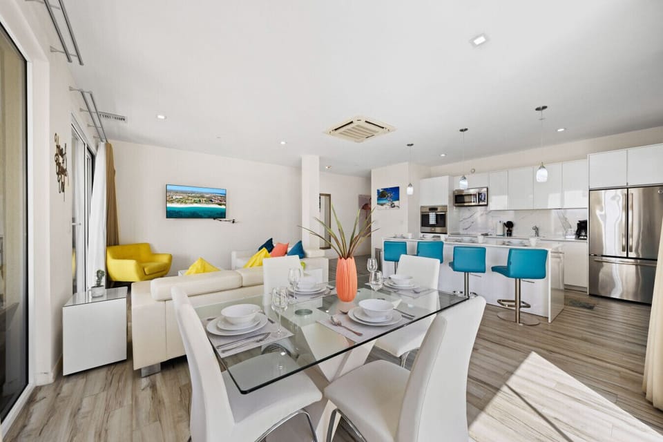 Welcome to this vibrant space! With cozy seating and a stylish dining area, it's perfect for relaxing or sharing meals. The colorful accents and open layout create a warm atmosphere. Come enjoy your stay here!