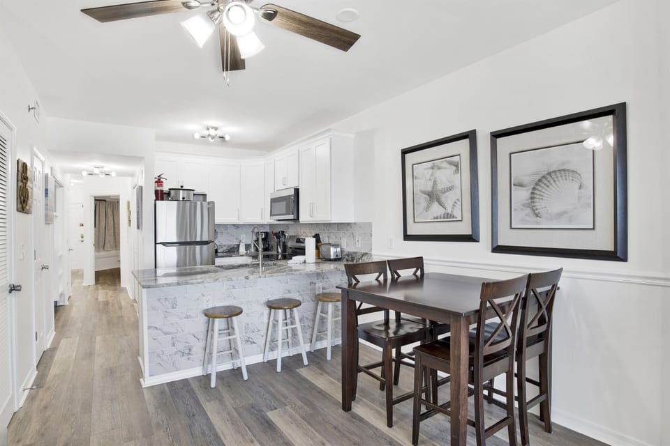 Dining area with counter height table and 4 chairs and breakfast bar with 3 barstools