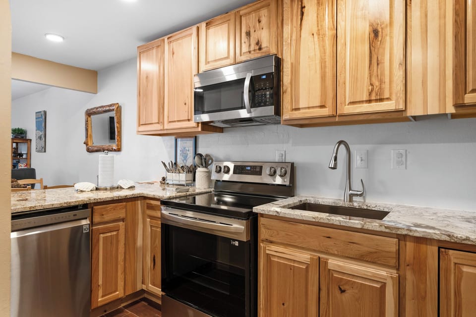 Your fully equipped kitchen invites culinary adventures with beautiful wood cabinets, granite counters, and stainless appliances.