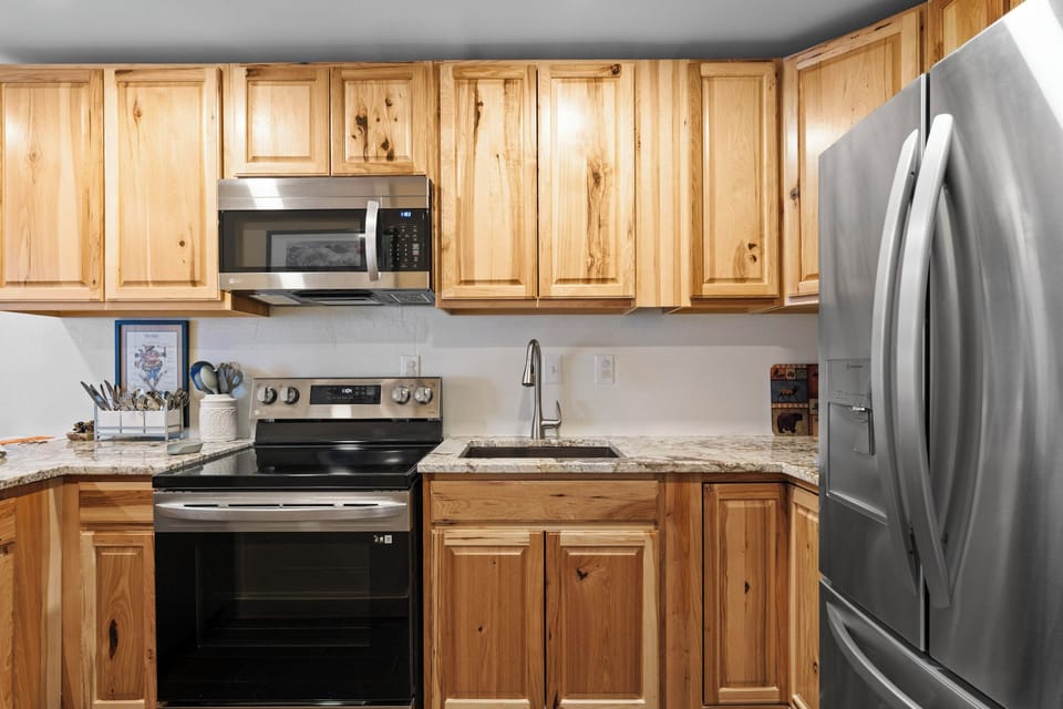 Your fully equipped kitchen features warm wood cabinets, granite counters, and stainless appliances for comfortable cooking.