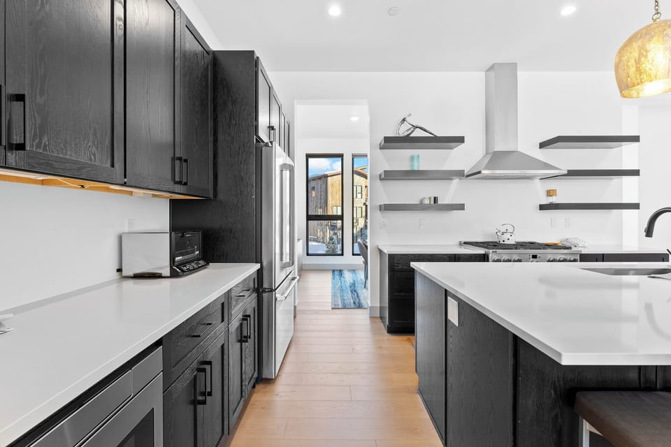 Your chef-worthy kitchen awaits with sleek dark cabinetry, pristine quartz countertops, and professional-grade appliances for memorable meal preparation.