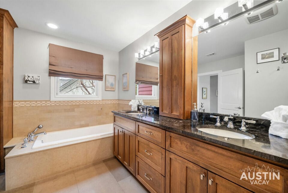 Soak up the sun in this luxurious primary bath, featuring a deep soaking tub and a double vanity with plenty of counter space.