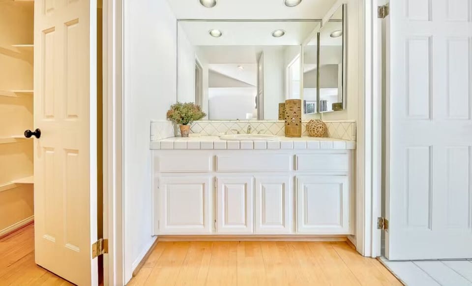 En suite bathroom with vanity, shower/tub combo and walk in closet