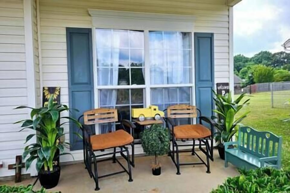 Charming front yard with cozy seating and a table, perfect for outdoor relaxation.