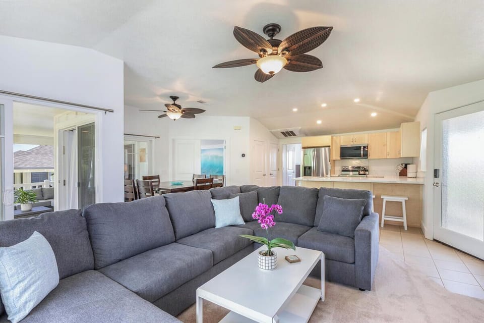 Comfortable living room with ample seating and ceiling fan.