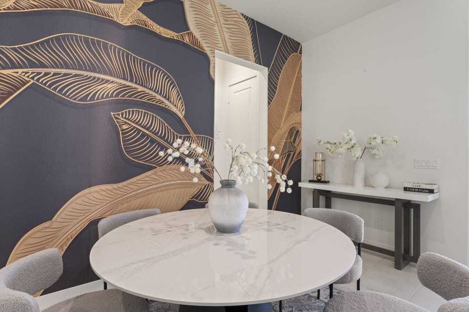 Dining nook w/ bold accent wall, round table & stylish seating for meals