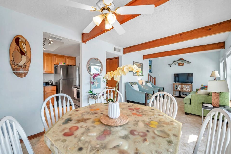 Open dining space flowing into the living area, framed by exposed beams & warm wood accents.