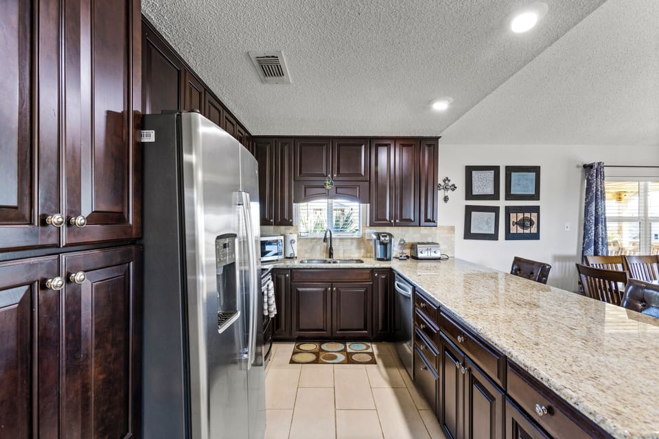 Full sized kitchen, featuring a fridge, coffee maker, stove and oven.