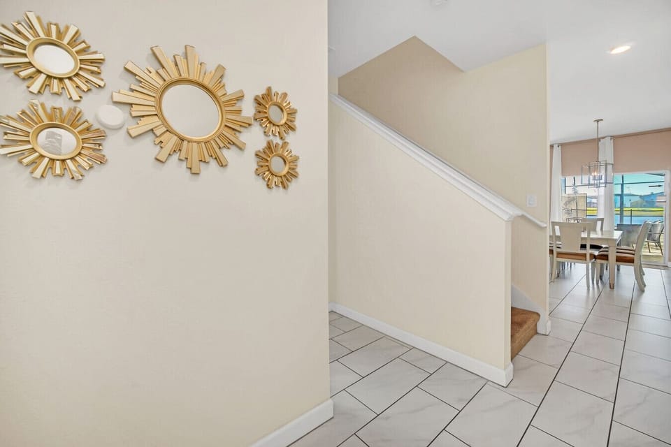 Bright entryway featuring stylish gold mirror accents and tiled flooring.