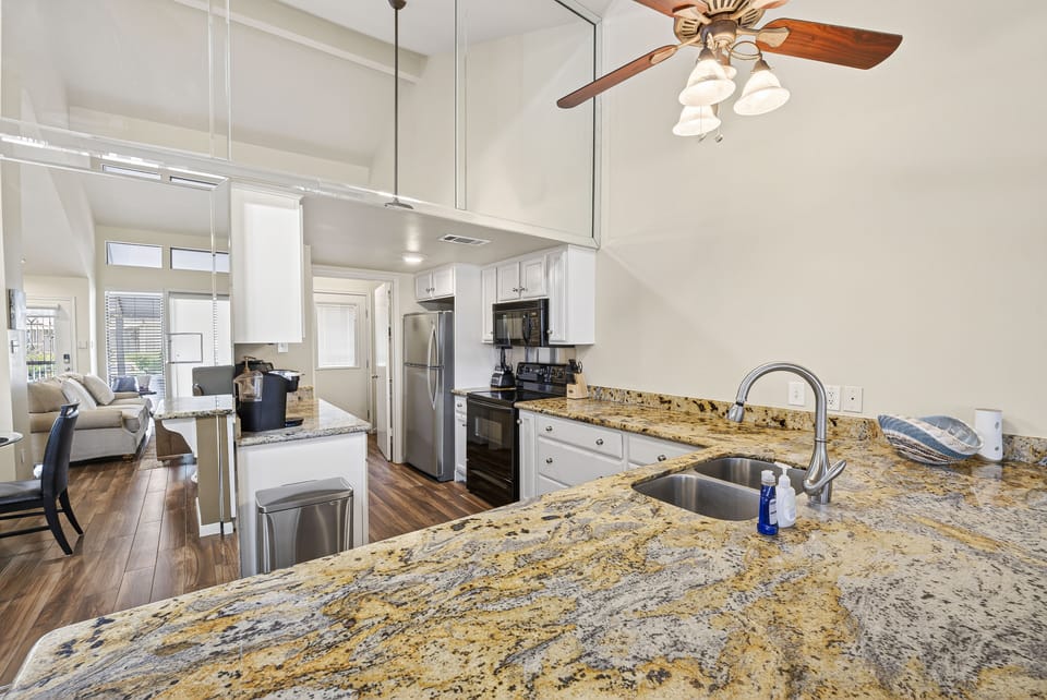 Spacious open-concept kitchen with granite counters & breakfast bar seating.
