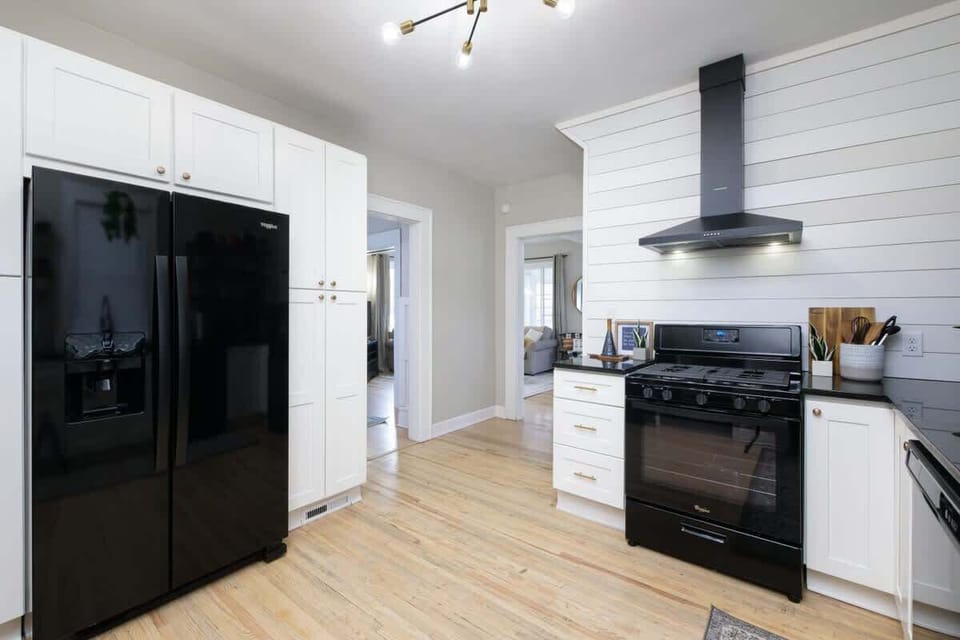 Kitchen w/ dark fridge, stove & clean layout blending modern style w/ warmth