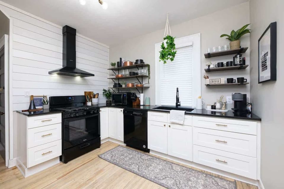 Sleek kitchen w/ black & white cabinetry, open shelving & plenty of prep space