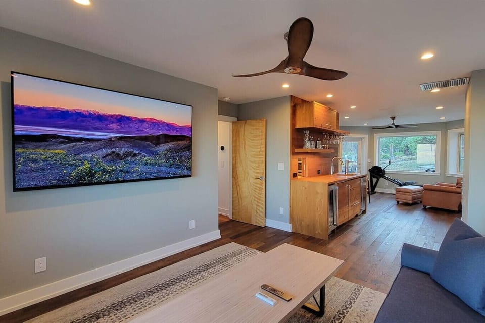 TV room with smart TV, pull out couch, wet bar, exercise equipment, and game table