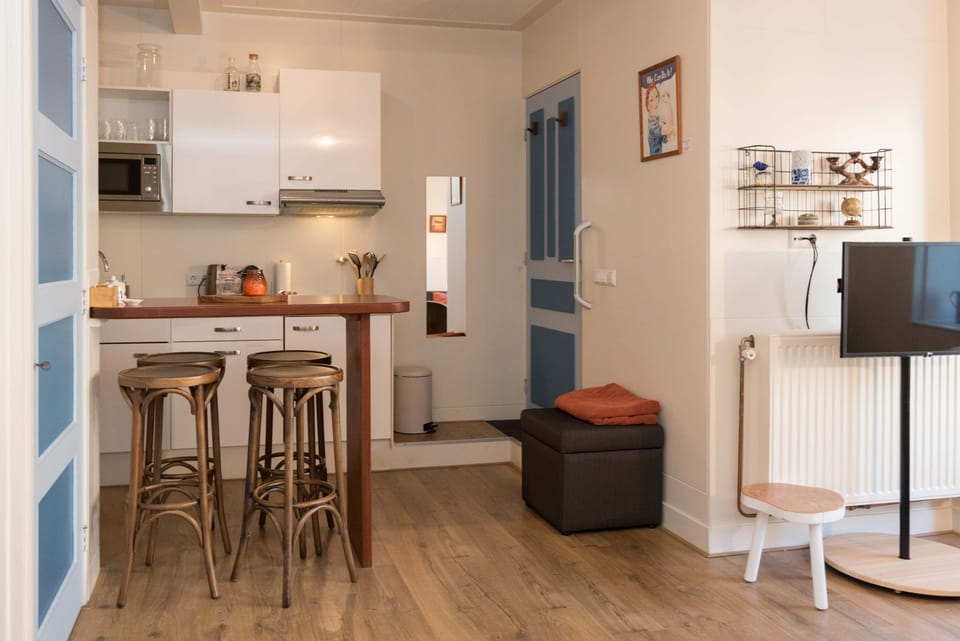 The warm dining area with wooden bar stools and a convenient kitchen layout makes dining comfortable and easy.