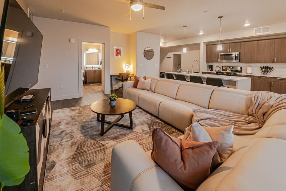 Beautifully designed living room. 75` TV, leather sofa and amazing views of mountains and city skyline.