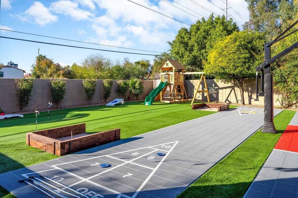 Backyard bliss at its finest—shuffleboard, corn hole, horseshoes, putt-putt, and a kid's playground. Perfect for endless fun! 