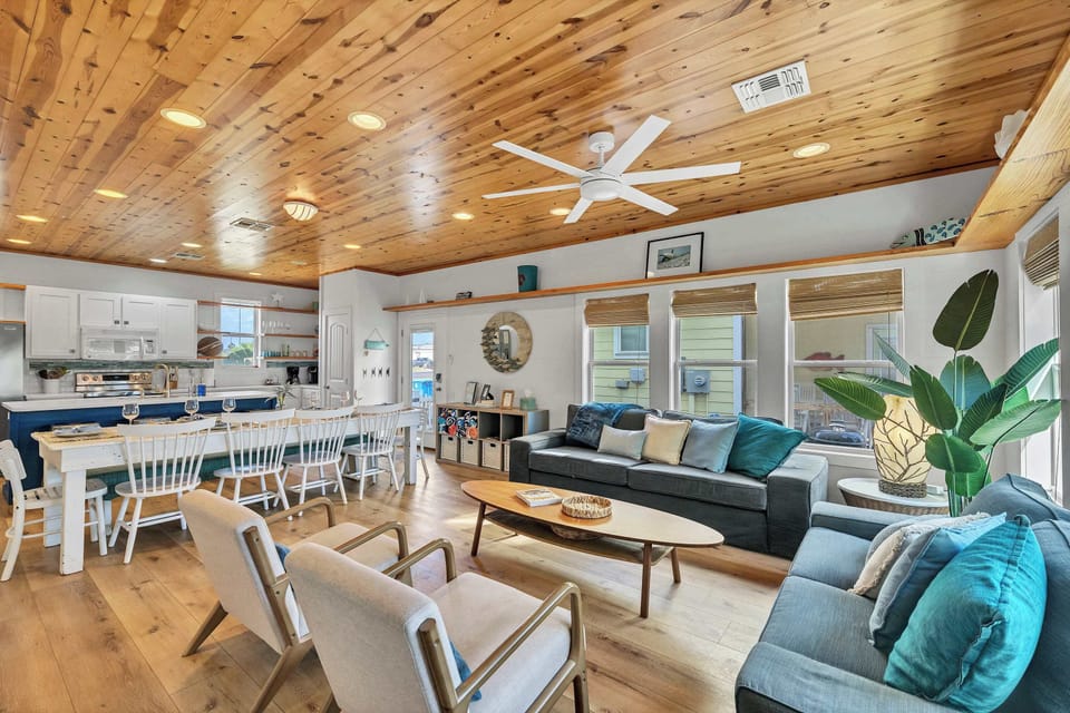 Spacious living room with two sofas, two lounge chairs, and a smart TV with free Spectrum cable and streaming apps.