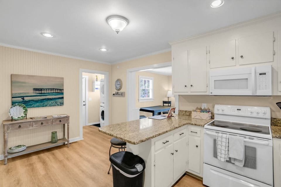 Continuing down the hall into the kitchen, equipped with an electric stove, microwave, coffee maker, and fridge, perfect for all your cooking and brewing needs.