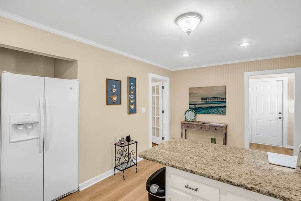 Continuing down the hall into the kitchen, equipped with an electric stove, microwave, coffee maker, and fridge, perfect for all your cooking and brewing needs.