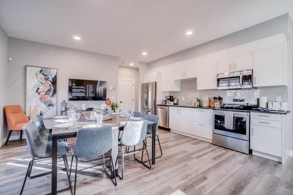 Modern Kitchen Delight: A sleek and well-equipped space with light grey walls, white countertops, and ample storage, offering a delightful dining area and efficient appliances for effortless meal preparation and comfortable gatherings.