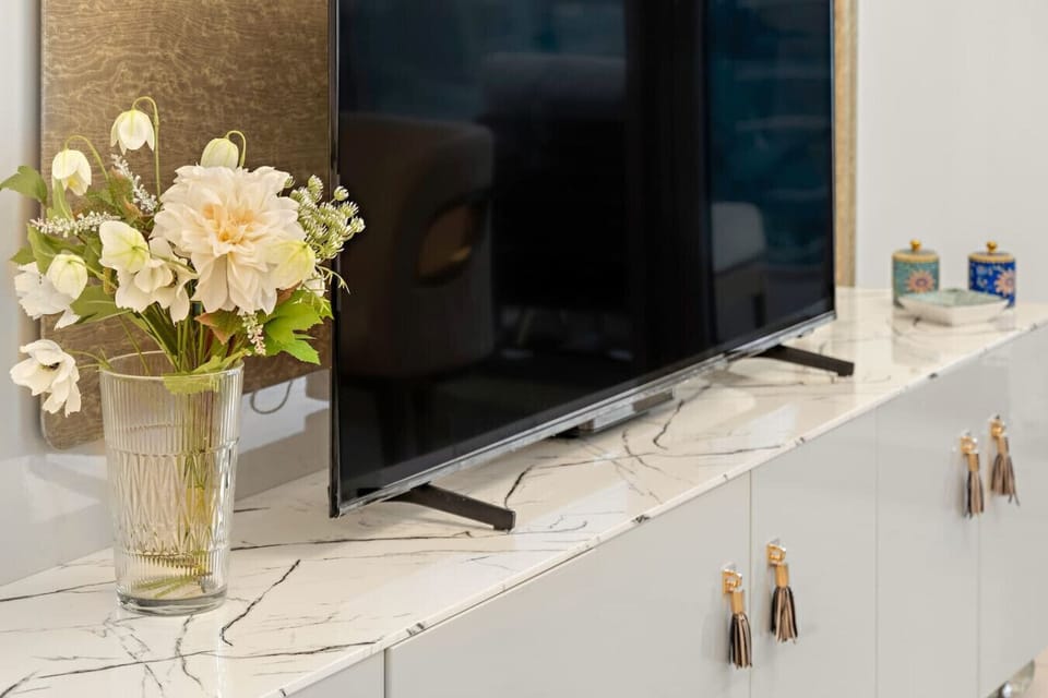 Living Room: Elegantly designed with modern decor and vibrant flowers, perfect for relaxation!